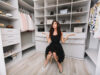 Young Brunette Woman Sitting In A Huge Dressing Room Thinks Over The Choice Of Clothes, She Is Dressed Stylish Black Outfit And Silver Shoes, Expressing True Positive Face Emotions