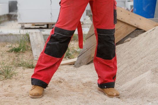 unrecognizable,person,on,construction,site,wearing,protective,worker,red,black