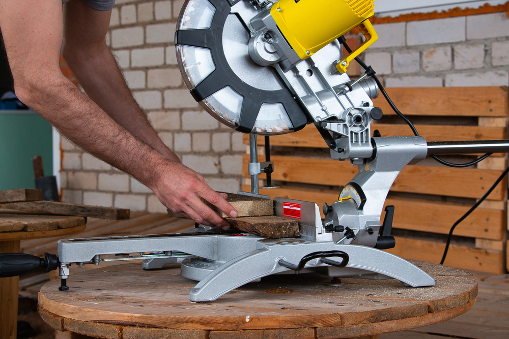 miter,saw,for,cutting,a,tree,on,a,wooden,table.